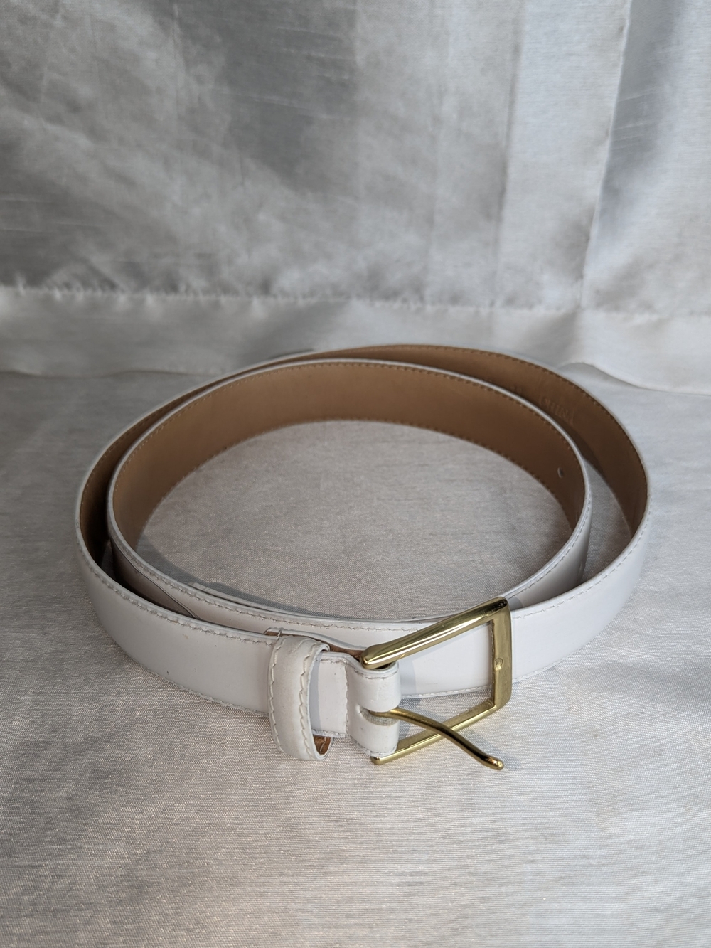 white full-grain cowhide leather dress belt paired with a polished, gold-toned